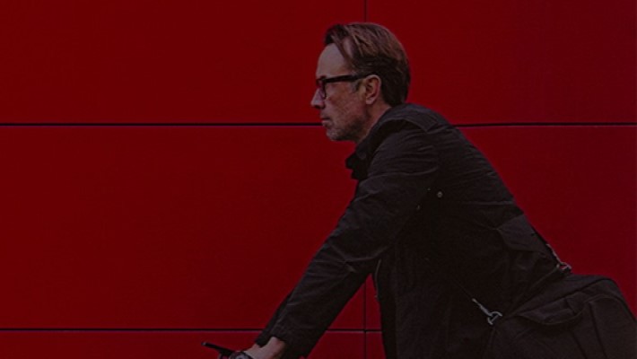 Man wearing an office bag riding a bike