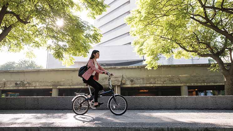 自転車に乗ってネットゼロオフィスへ通うう女性（画像はイメージ）