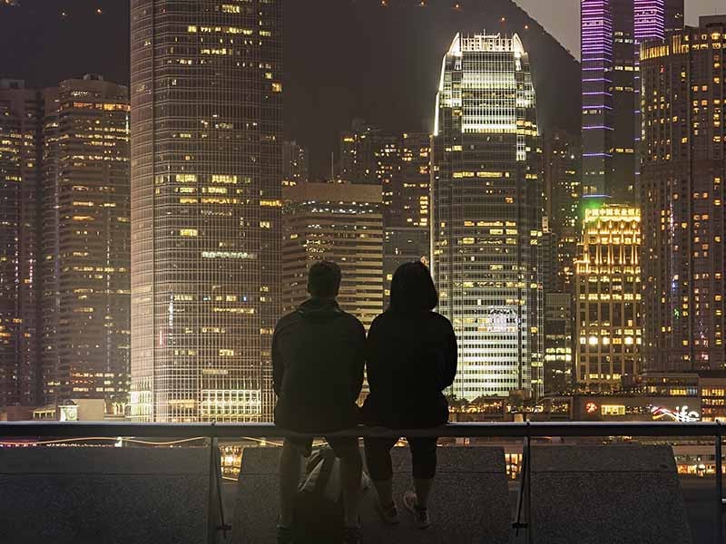 光に彩られた都市の夜景を望む男女