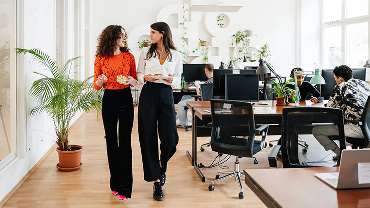 Employees talking at a corporate office that is implementing office greening