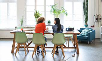 Two girls are discussing in office