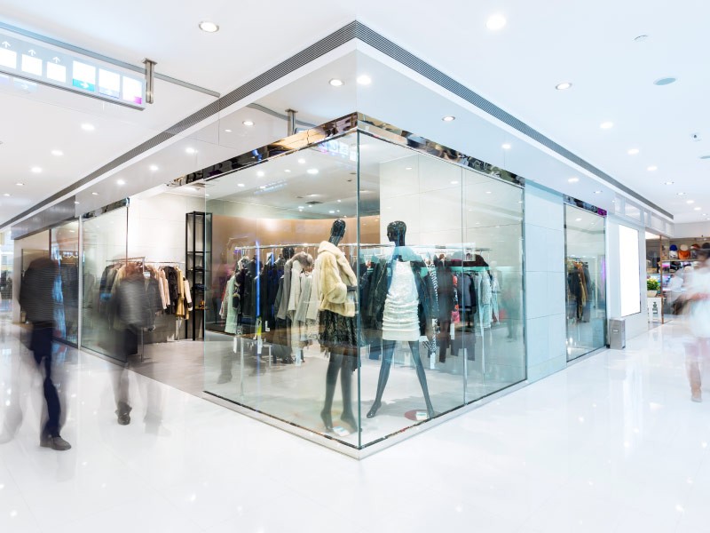 Motion shot of people passing by retail store 	