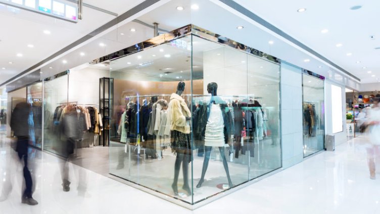 Motion shot of people passing by retail store 	