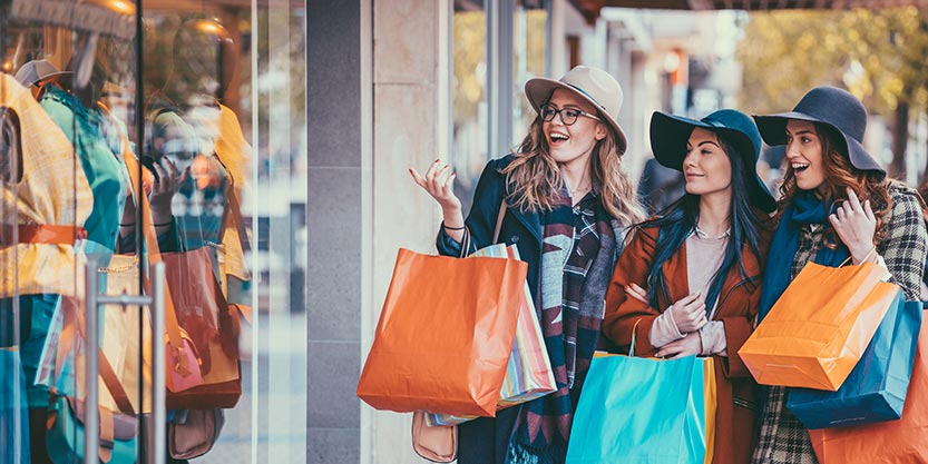 Friends are shopping clothes and holding bags