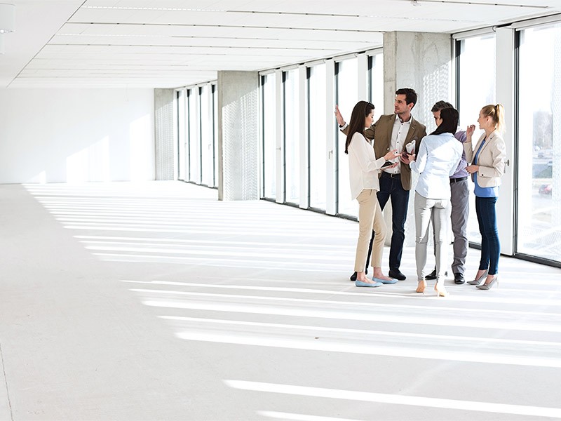 Full length of business people having discussion in empty office space