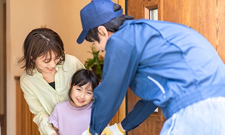 Young mother and child receiving a delivery from an e-commerce driver