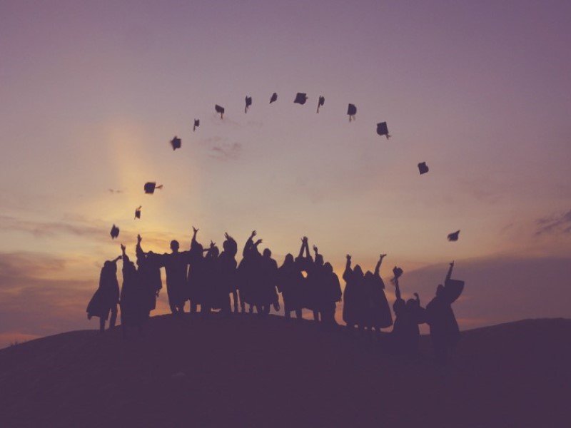 student throwing convocation hat in air