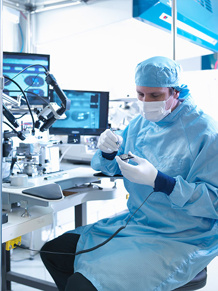 Lab technician works on microchip in advanced manufacturing laboratory